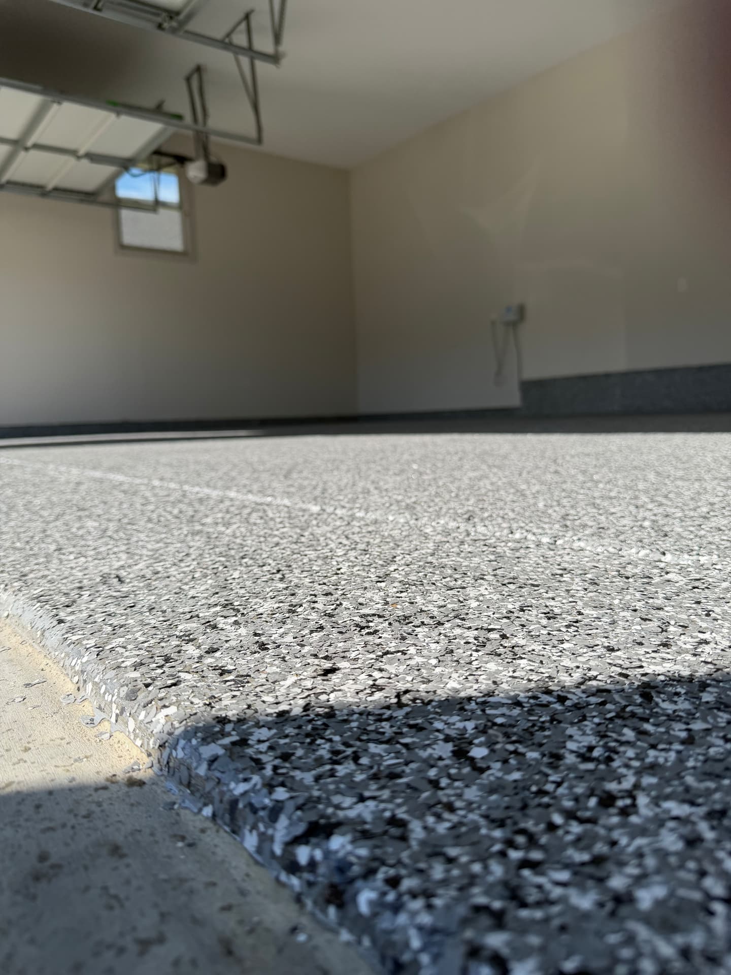 Edge detail of flake epoxy coating meeting the driveway